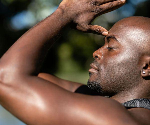 Person meditating peacefully in a sunlit room, embodying tranquility.